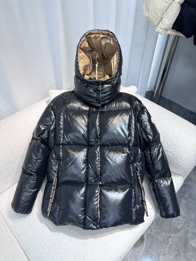 Moncler Parana羽绒服以其闪亮漆面尼龙面料脱颖而出，具有对比鲜明的内外色调。短款设计，连衫帽可在气候变暖时拆卸，大号拉绊从潮流品牌标志时尚汲取灵感，